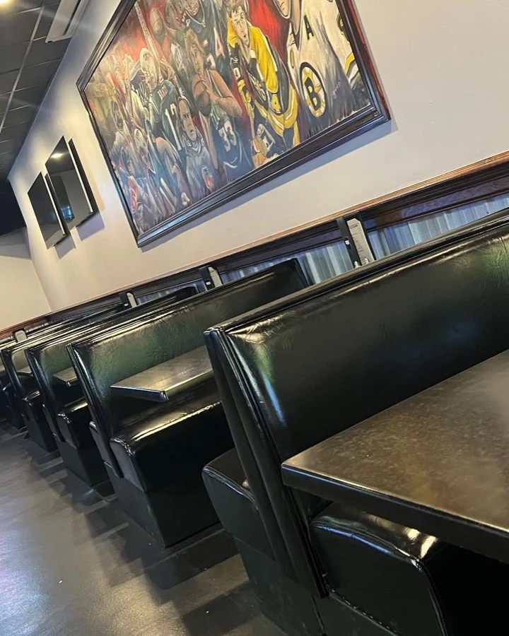 Booth seating below a hand-painted sports mural inside Players Sports Bar & Grille